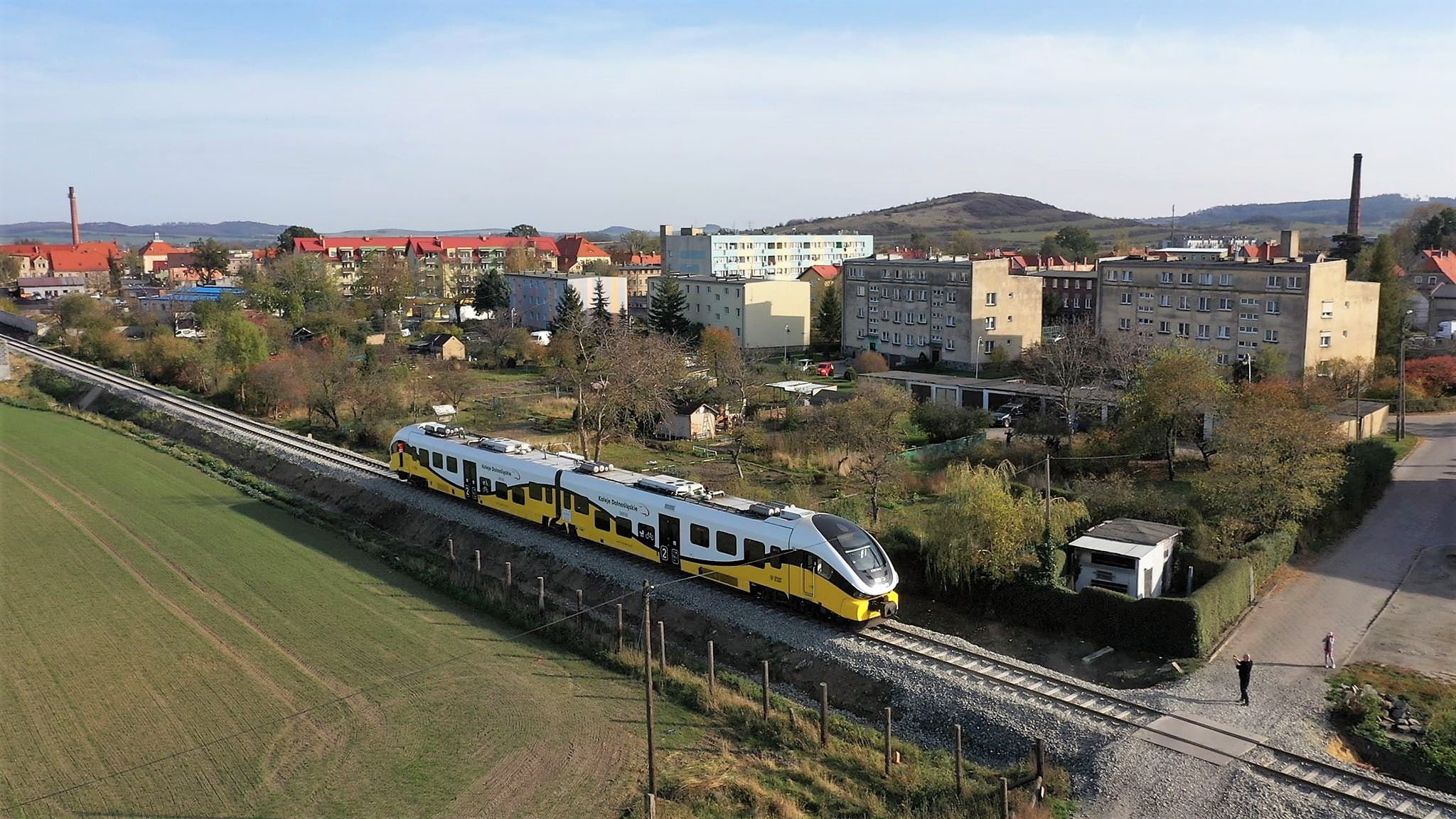 Zdjęcie przedstawia pociąg i panorame Bielawy w tle