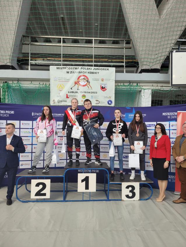 Laureaci na podium z pamiątkowymi medalami, dyplomami i nagrodami