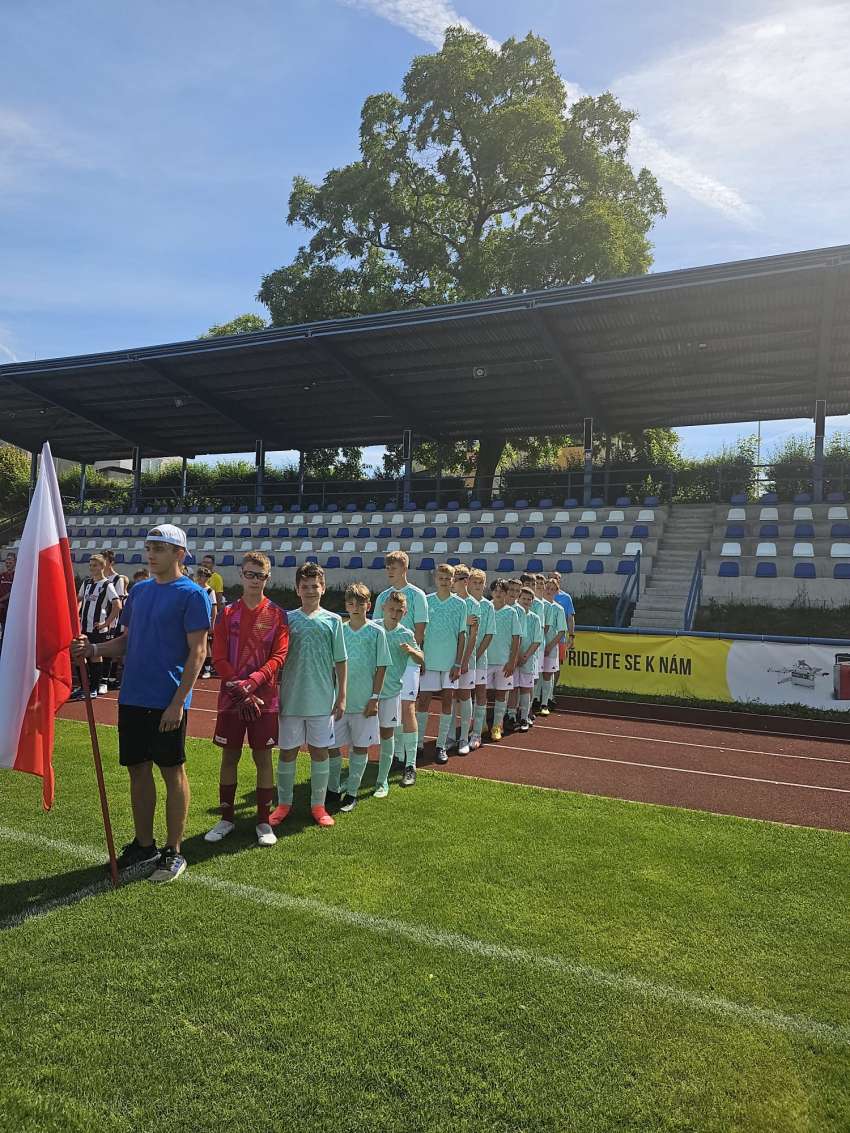 Reprezentacja z Bielawy z biało-czerwoną flagą na murawie boiska na turnieju piłki nożnej w Kostelcu