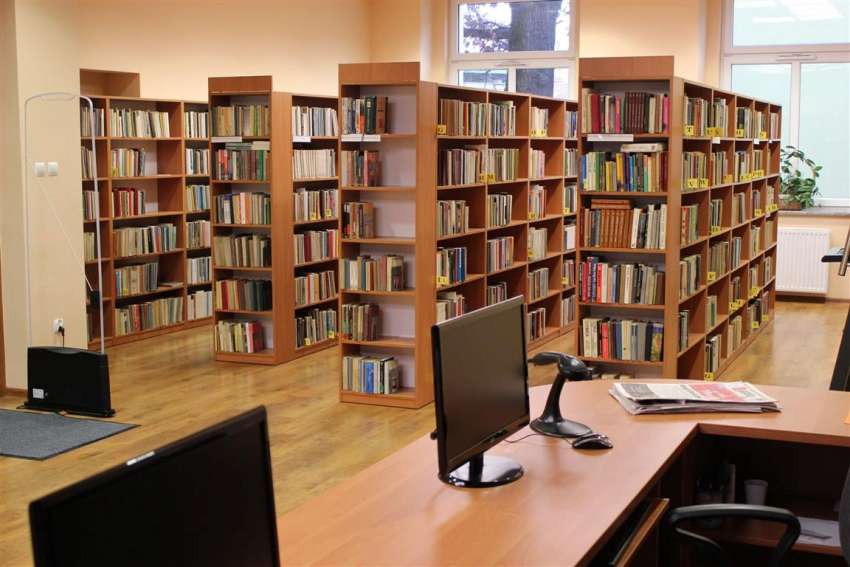 Wnętrze biblioteki - regały z książkami, biurka, komputery