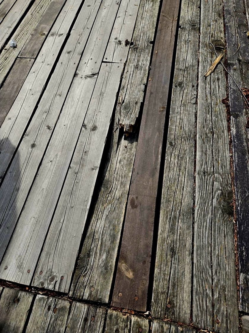 Uszkodzone deski pomostu nad Jeziorem Bielawskim