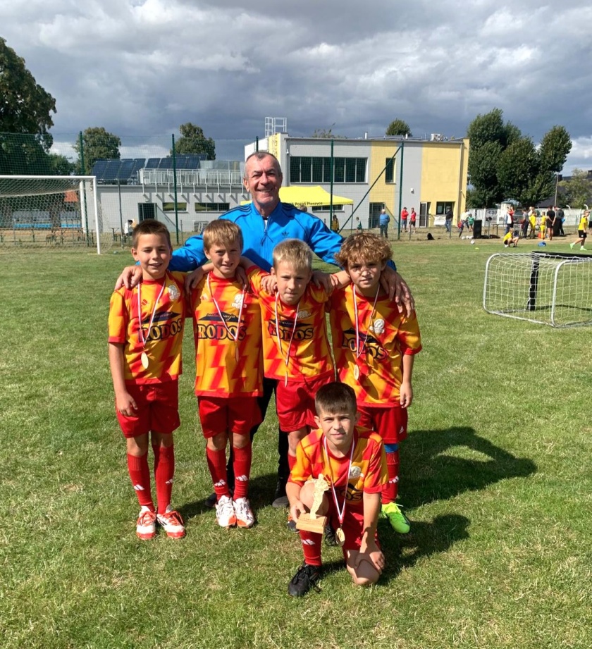 Zawodnicy UKS Siódemka Bielawa z medalami i statuetką na murawie boiska