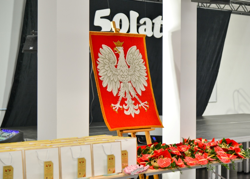 Jubileuszowa scenografia z Godłem RP i kwiatami